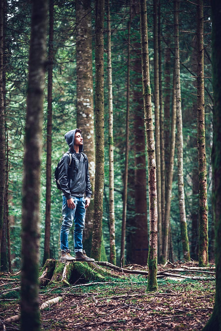 Hooded man posing in the forest